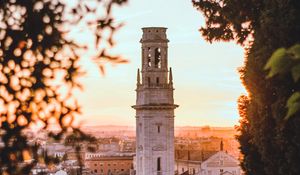 Preview wallpaper tower, city, architecture, branches, sunset