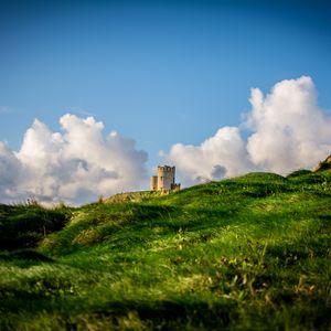 Preview wallpaper tower, hill, grass, clouds, nature