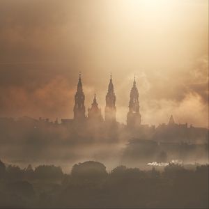 Preview wallpaper towers, buildings, fog, trees
