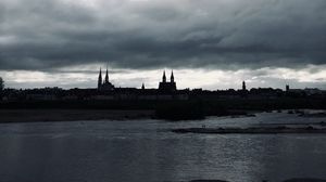 Preview wallpaper towers, buildings, silhouettes, river, evening