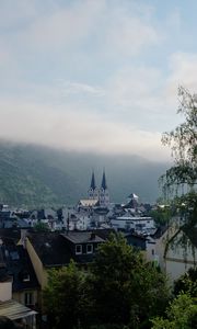 Preview wallpaper towers, houses, mountains, fog, city