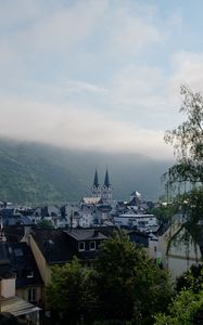Preview wallpaper towers, houses, mountains, fog, city
