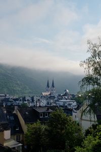 Preview wallpaper towers, houses, mountains, fog, city