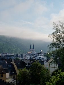 Preview wallpaper towers, houses, mountains, fog, city