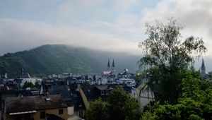 Preview wallpaper towers, houses, mountains, fog, city