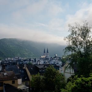 Preview wallpaper towers, houses, mountains, fog, city