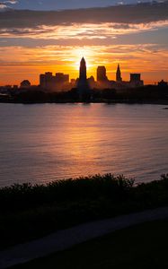 Preview wallpaper towers, skyscrapers, silhouettes, sea, sunset, dark