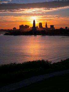 Preview wallpaper towers, skyscrapers, silhouettes, sea, sunset, dark