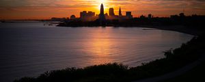 Preview wallpaper towers, skyscrapers, silhouettes, sea, sunset, dark
