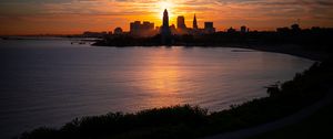 Preview wallpaper towers, skyscrapers, silhouettes, sea, sunset, dark