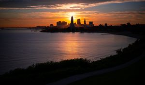 Preview wallpaper towers, skyscrapers, silhouettes, sea, sunset, dark