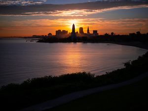 Preview wallpaper towers, skyscrapers, silhouettes, sea, sunset, dark