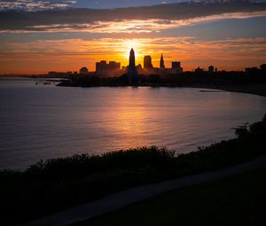 Preview wallpaper towers, skyscrapers, silhouettes, sea, sunset, dark