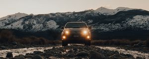 Preview wallpaper toyota, vehicle, suv, front view, road, rocks, headlights