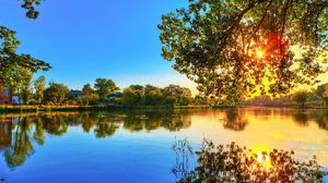 Preview wallpaper tree, river, krone, leaves, evening, sun, decline, reflection, waves, colors