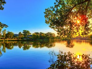 Preview wallpaper tree, river, krone, leaves, evening, sun, decline, reflection, waves, colors