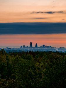 Preview wallpaper trees, city, twilight, view, tops, clouds