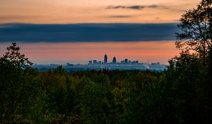 Preview wallpaper trees, city, twilight, view, tops, clouds