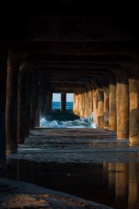 Preview wallpaper tunnel, water, waves, sand, pier