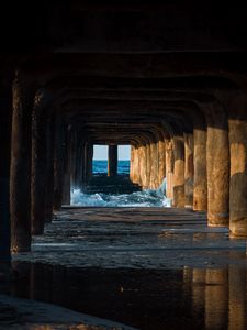 Preview wallpaper tunnel, water, waves, sand, pier