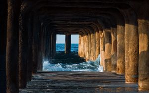 Preview wallpaper tunnel, water, waves, sand, pier