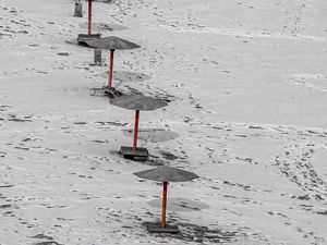 Preview wallpaper umbrellas, winter, snow, beach, landscape, red, bw