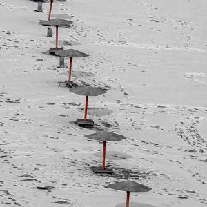 Preview wallpaper umbrellas, winter, snow, beach, landscape, red, bw