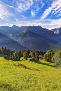 Preview wallpaper valley, grass, trees, mountains, sunlight, landscape