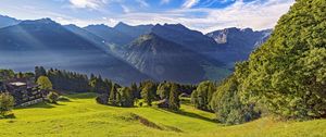 Preview wallpaper valley, grass, trees, mountains, sunlight, landscape