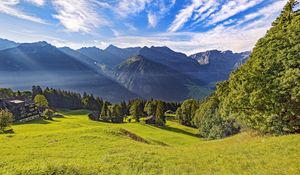 Preview wallpaper valley, grass, trees, mountains, sunlight, landscape