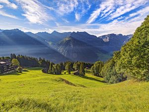 Preview wallpaper valley, grass, trees, mountains, sunlight, landscape