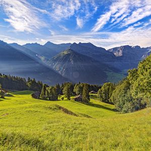 Preview wallpaper valley, grass, trees, mountains, sunlight, landscape