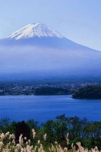 Preview wallpaper volcano, clouds, coast, top, city, water, grass