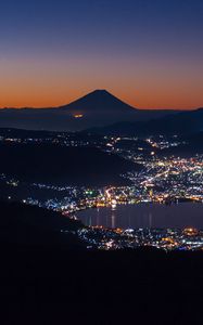 Preview wallpaper volcano, mountains, silhouettes, lights, bay, city, night