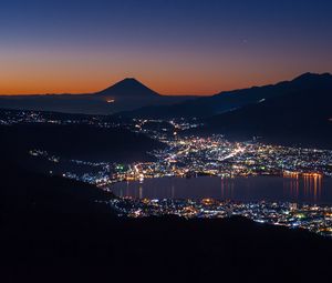 Preview wallpaper volcano, mountains, silhouettes, lights, bay, city, night