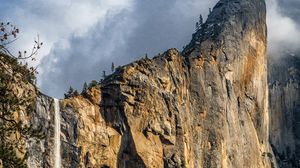 Preview wallpaper waterfall, cliff, rocks, trees, branches
