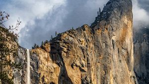 Preview wallpaper waterfall, cliff, rocks, trees, branches