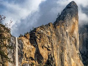 Preview wallpaper waterfall, cliff, rocks, trees, branches