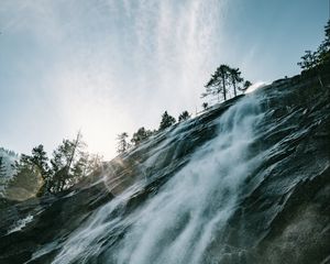 Preview wallpaper waterfall, cliff, trees, sunlight, flare