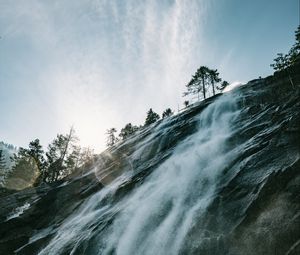 Preview wallpaper waterfall, cliff, trees, sunlight, flare