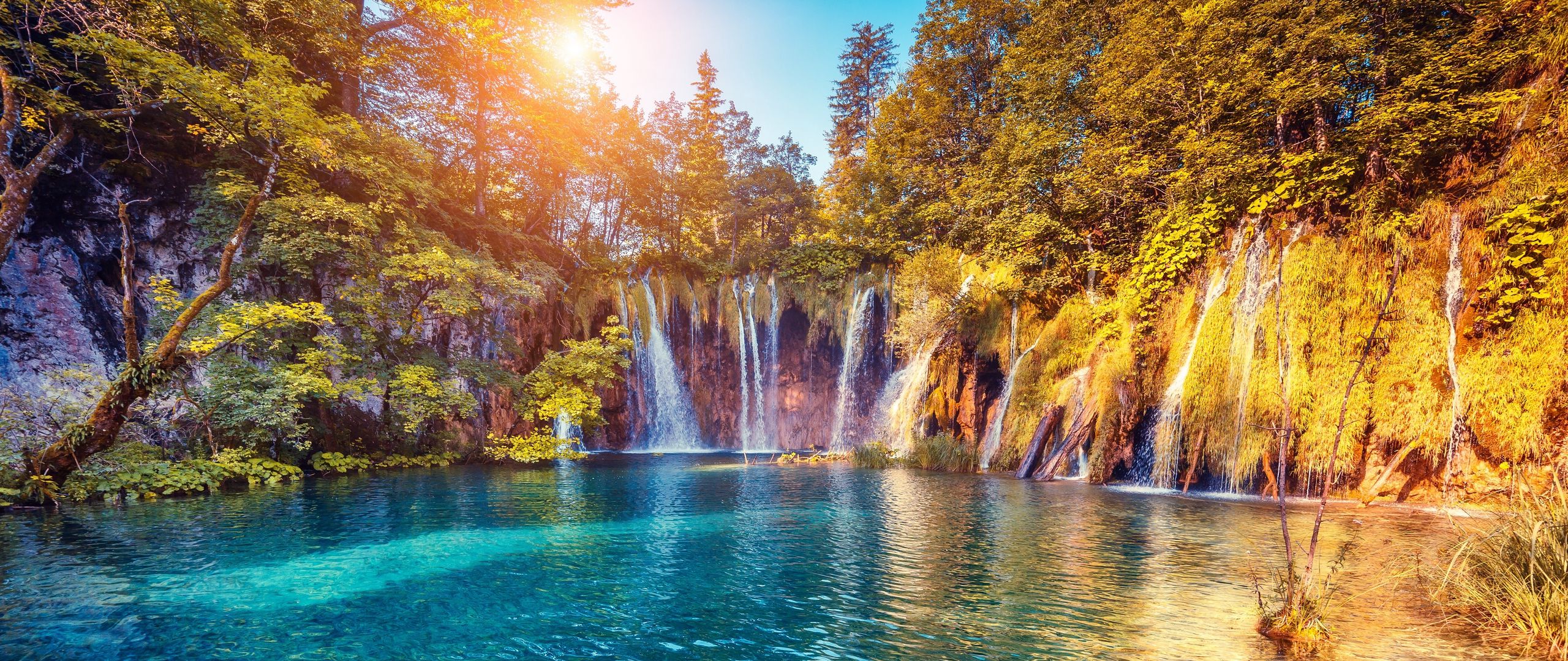 Download wallpaper 2560x1080 waterfall, precipice, sunlight, summer,  bright, trees dual wide 1080p hd background