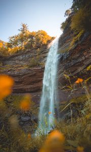 Preview wallpaper waterfall, rock, cliff, grass, flowers, nature