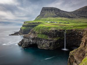 Preview wallpaper waterfall, rock, sea, valley, houses