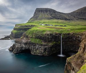 Preview wallpaper waterfall, rock, sea, valley, houses