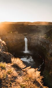 Preview wallpaper waterfall, rocks, cliff, rays, sky