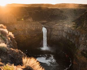Preview wallpaper waterfall, rocks, cliff, rays, sky