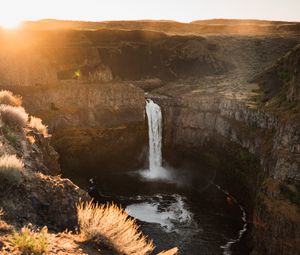 Preview wallpaper waterfall, rocks, cliff, rays, sky