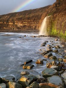 Preview wallpaper waterfall, stones, sea, cliffs, rainbow, nature