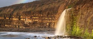 Preview wallpaper waterfall, stones, sea, cliffs, rainbow, nature