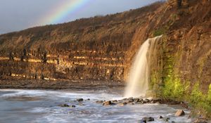 Preview wallpaper waterfall, stones, sea, cliffs, rainbow, nature